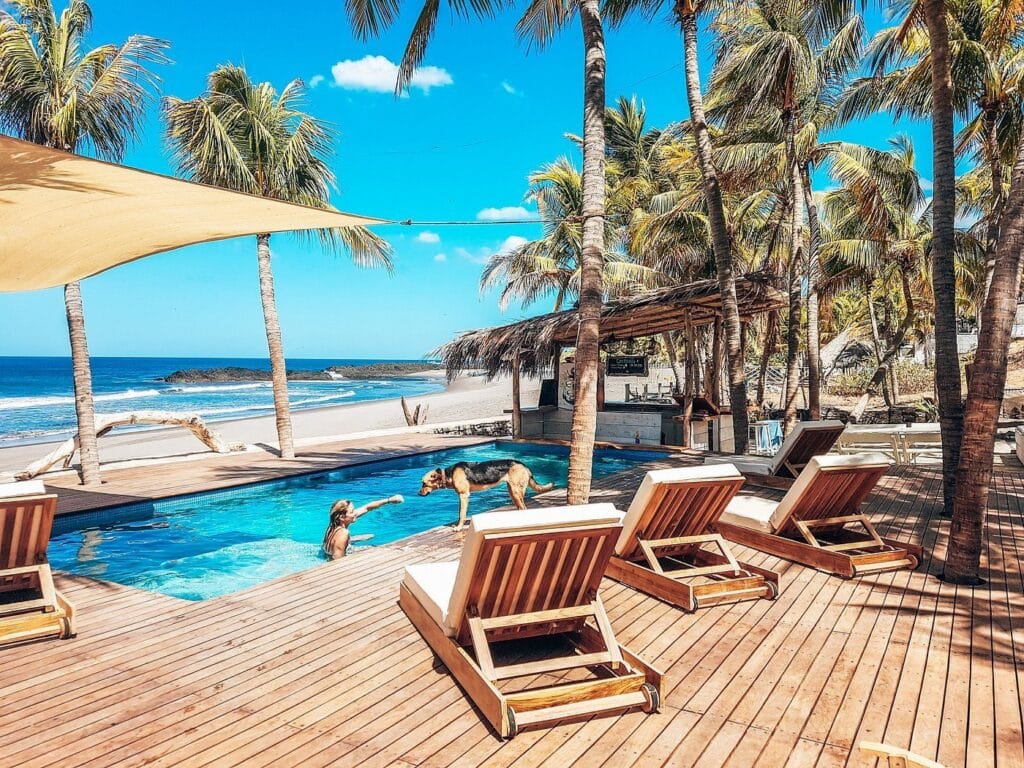 View of the oceanfront pool and beach chairs at Mandla Hotels in El Transito, Nicaragua