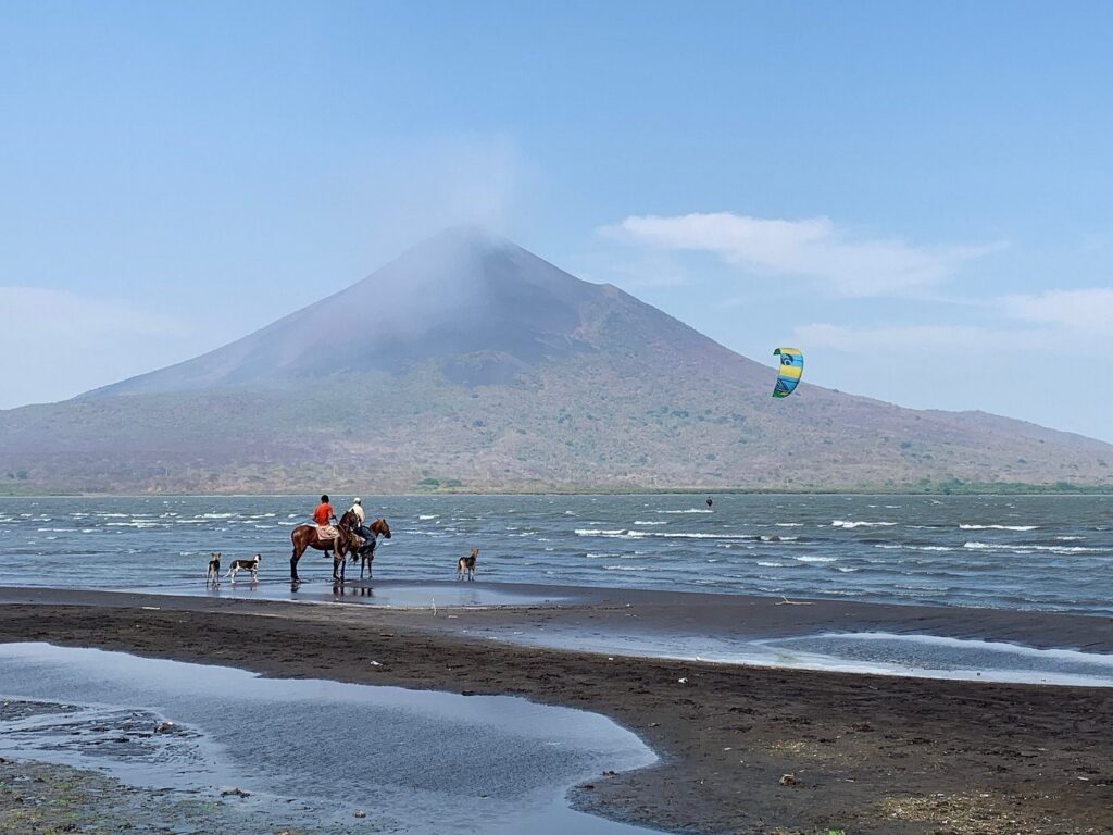 Two horseback riders looking out at Momotombo volcano in Nicaragua